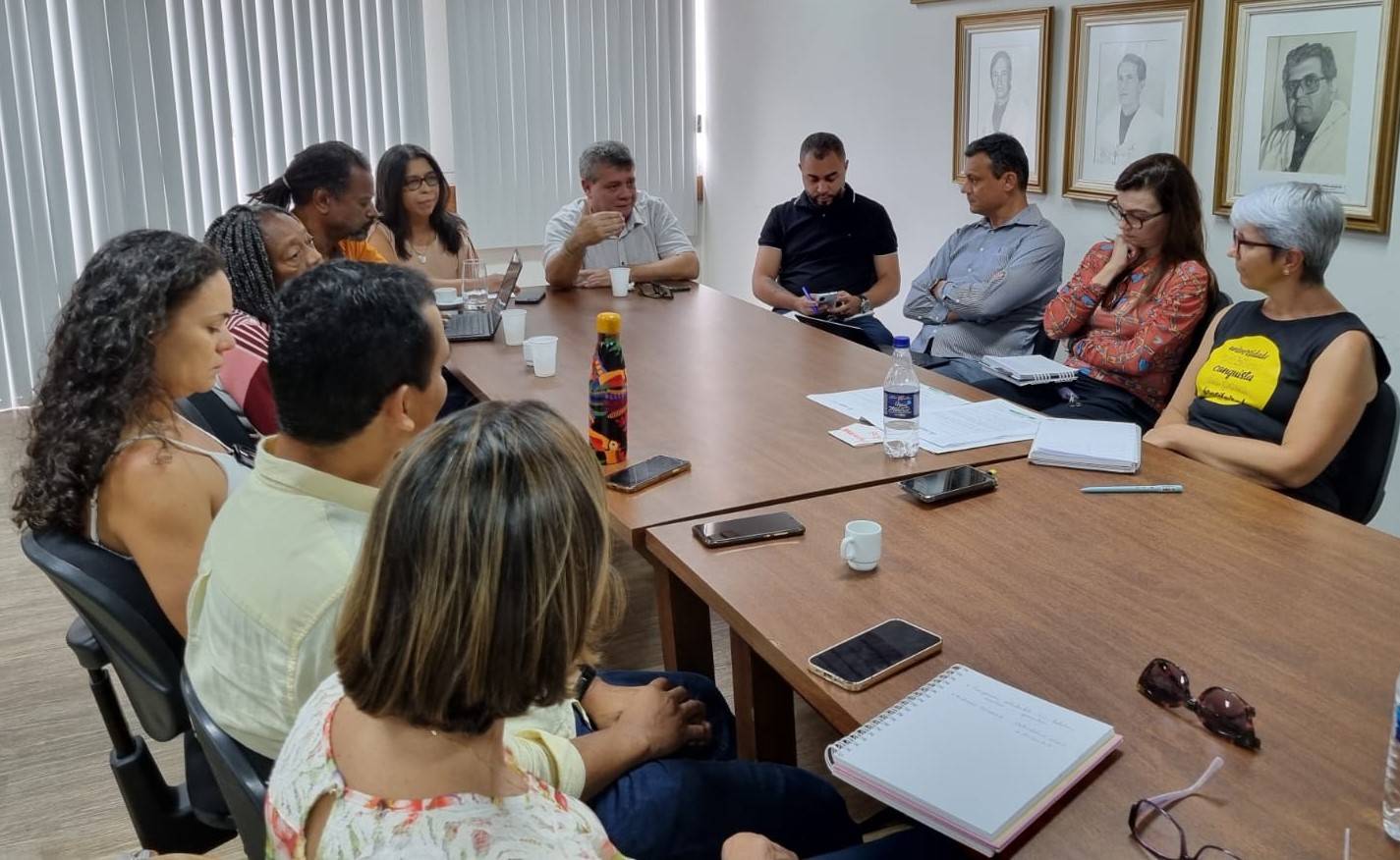 Foto da sala de reuniões, com gestores da Ufes e representantes da Adufes em volta da mesa.