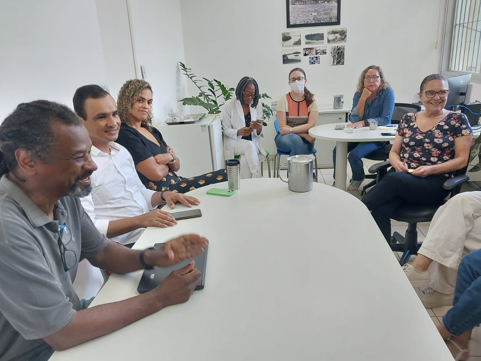Foto do pró-reitor Antônio Carlos Moraes e do diretor Iury Pessôa sentados à mesa diante da equipe do RU.