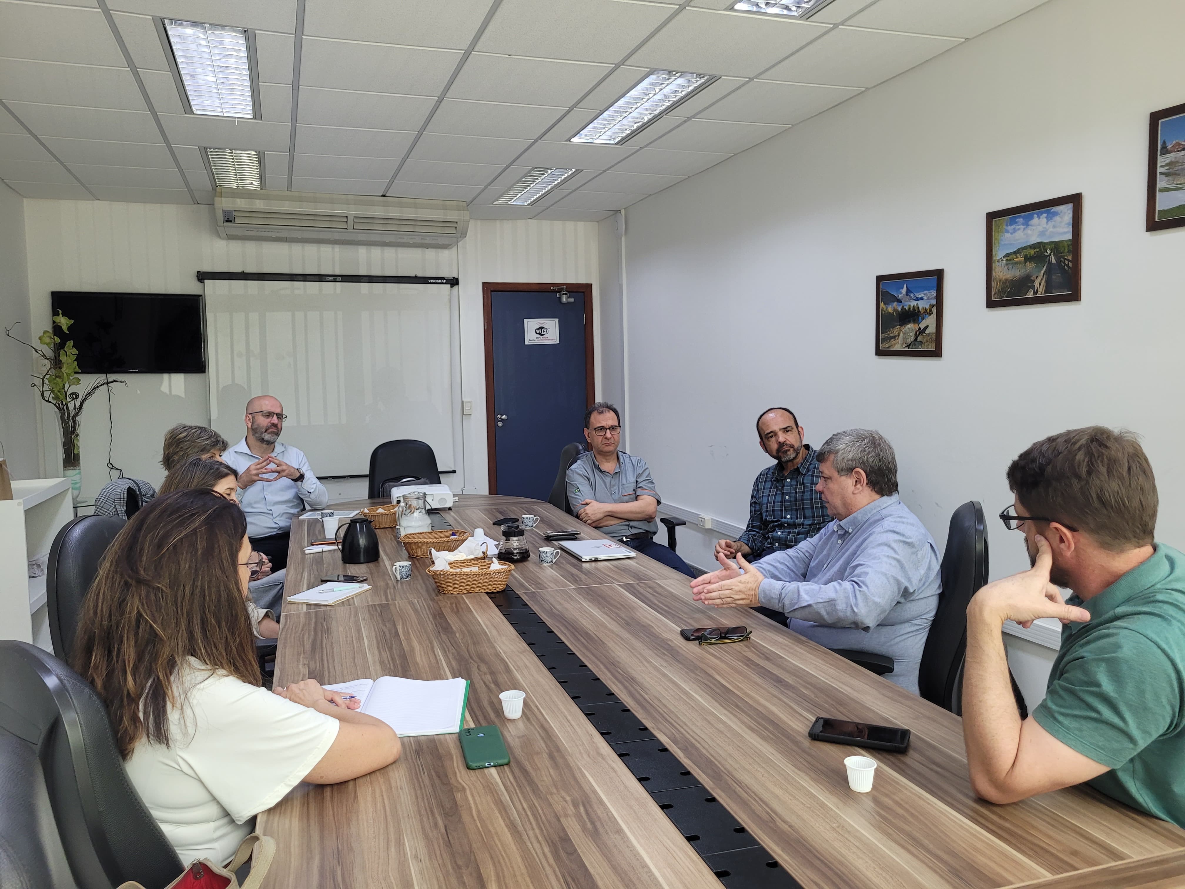 Foto da reunião, com todos os participante sentados em volta da mesa