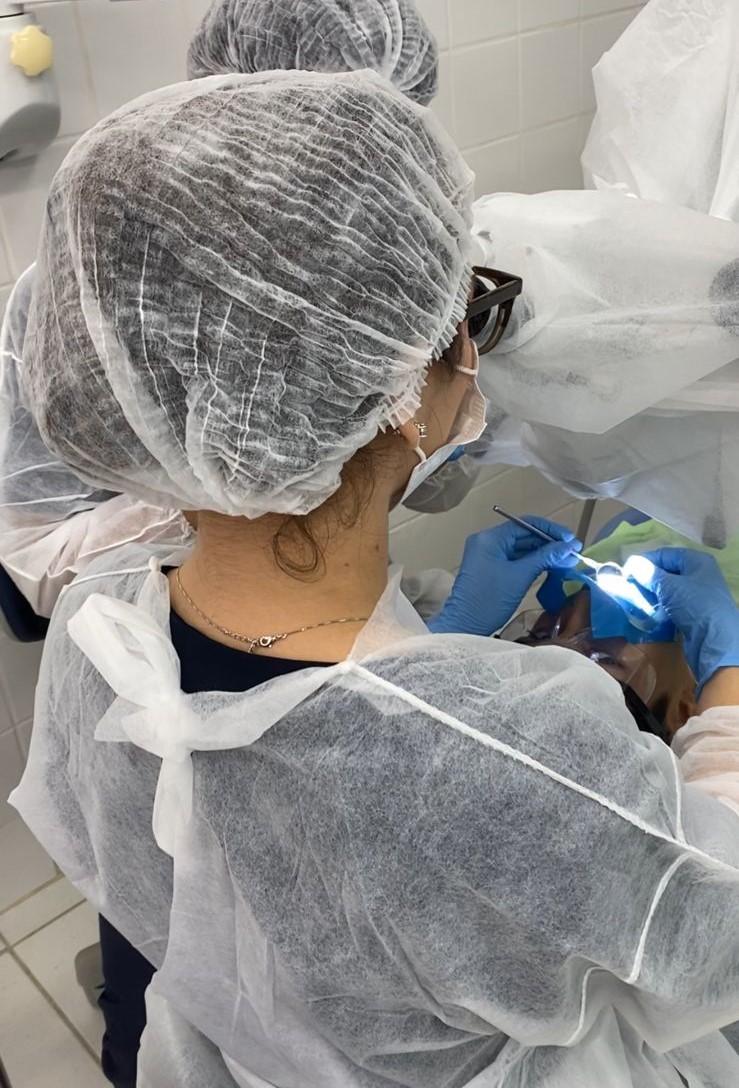 Foto de uma dentista realizando um procedimento em um paciente