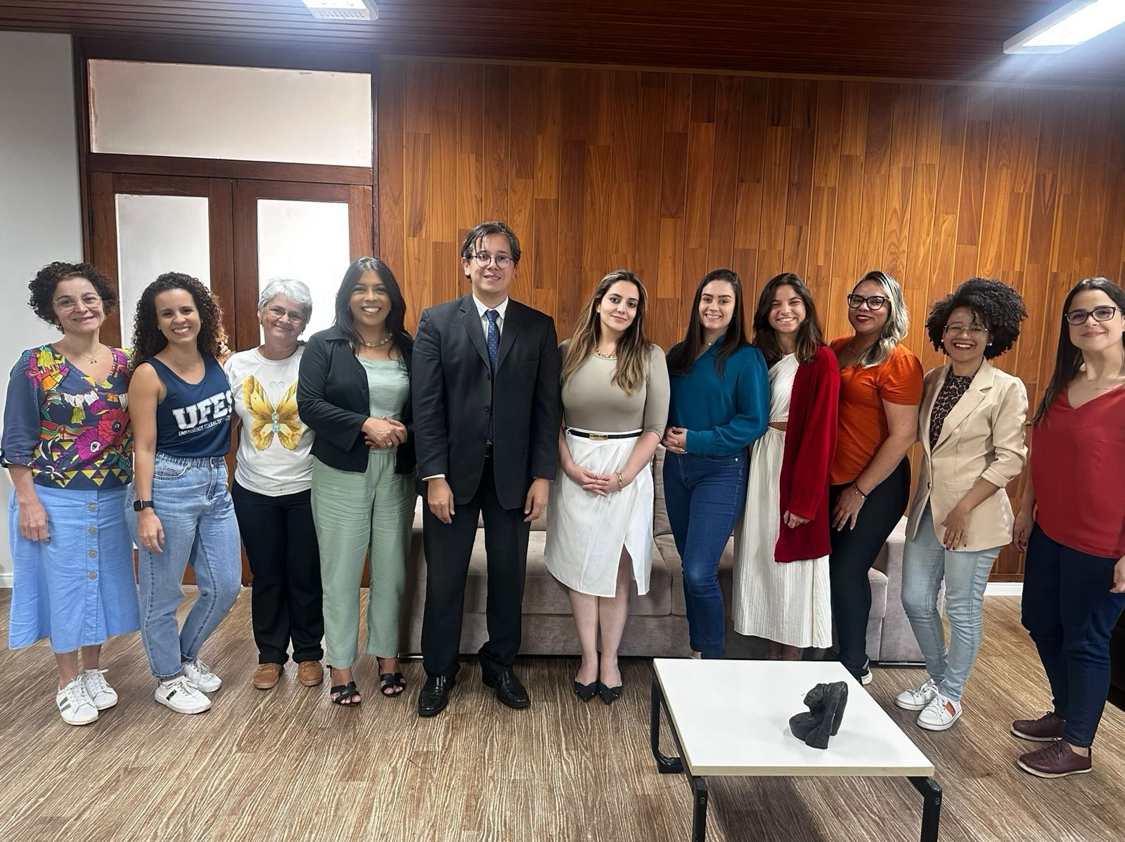 Foto das equipes da Siac e da Defensoria Pública, com a pessoas posando, em pé, na sala de reuniões da Reitoria.