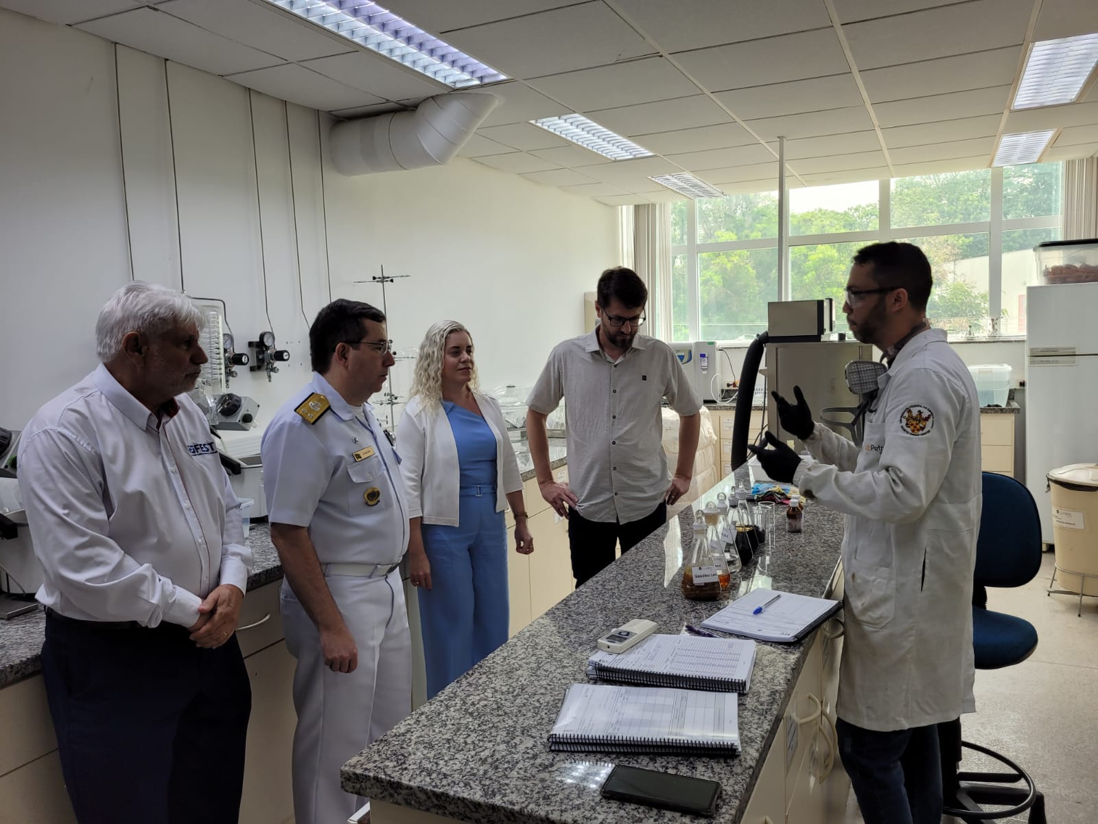 Foto do contra-almirante visitando um laboratório no LabPetro