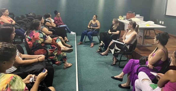 Foto de um grupo de mulheres reunidas em um auditório.