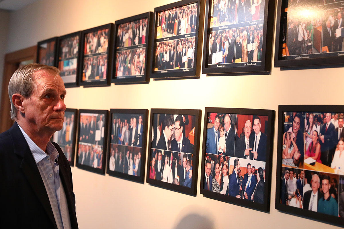 Foto do fotógrafo olhando uma exposição organizada por ele