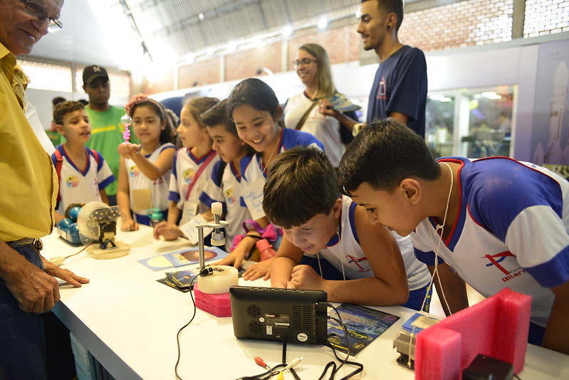 Foto de crianças observando curiosidades em um stand da SBPC Jovem