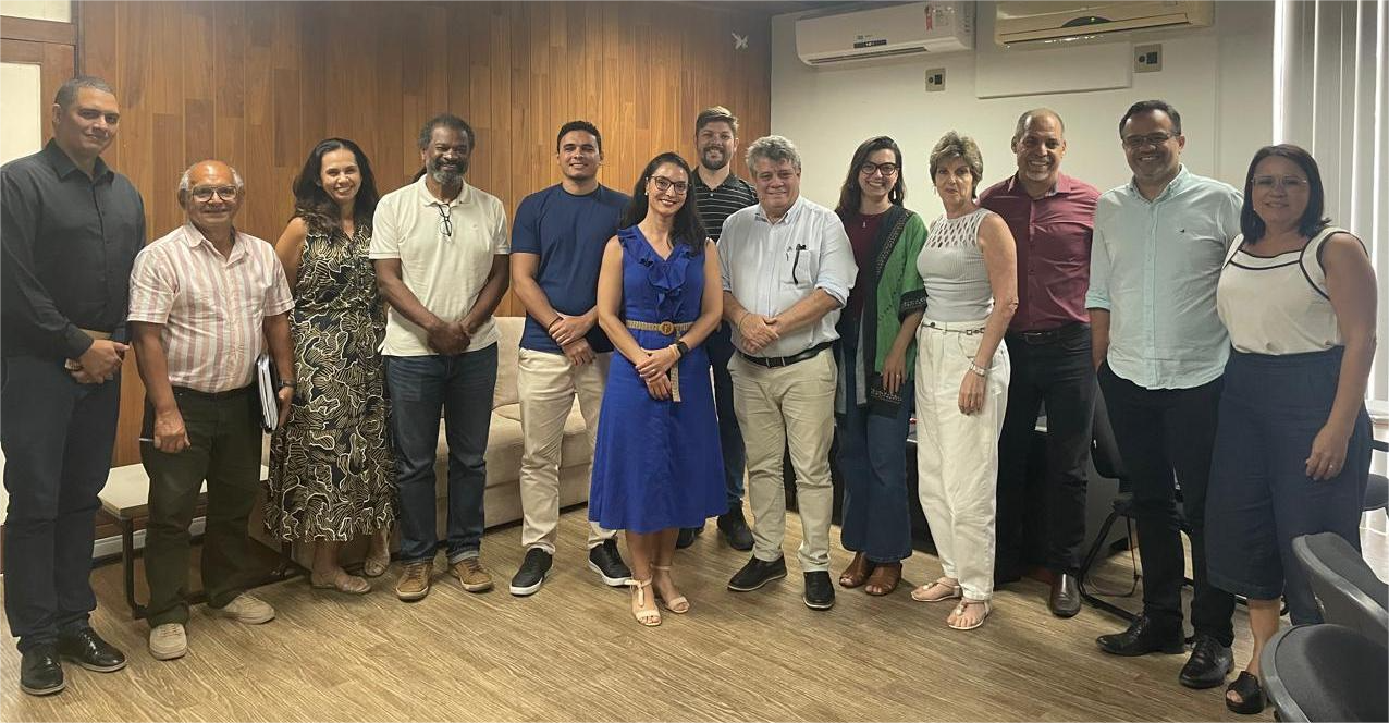 O reitor Eustáquio de Castro (ao centro, de camisa branca) e os membros do Comitê de Governança, Gestão de Riscos e Controles Internos, após a aprovação dos documentos Os membros do Comitê de Governança, Gestão de Riscos e Controles Internos em pé, na sala de reuniões da Reitoria