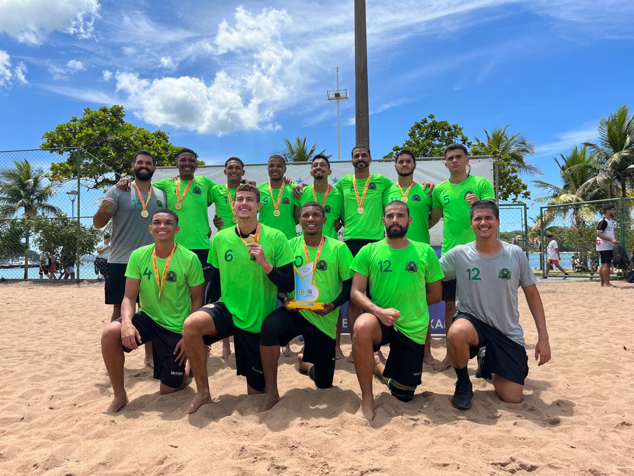 Equipe de handebol posa para foto com medalhas e troféu