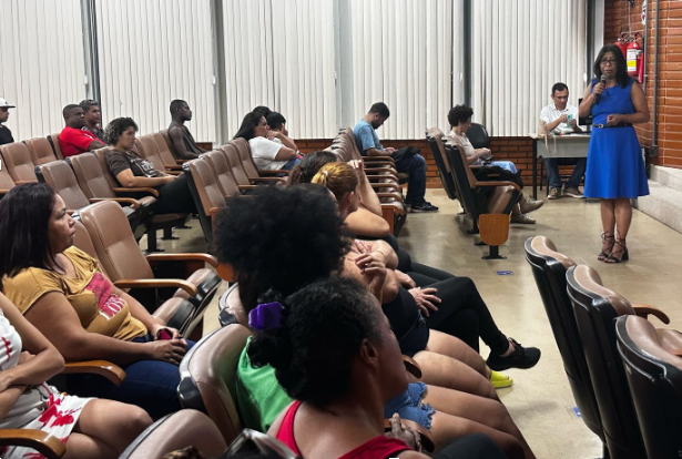 Foto da vice-reitora falando aos trabalhadores no auditório