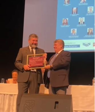 Foto do professor Francisco Vieira Lima Neto recebendo a placa das mãos do reitor da Ufes