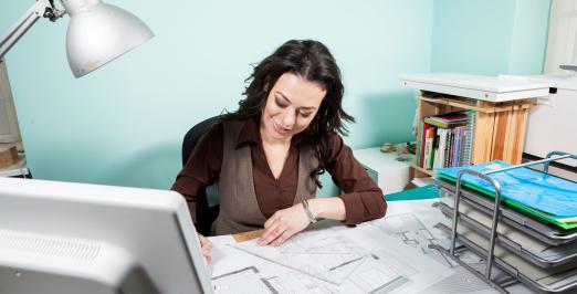 Foto de uma arquiteta em sua mesa de trabalho