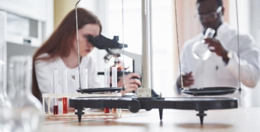 Imagem de uma pesquisadora branca e um pesquisador negro trabalhando em um laboratório