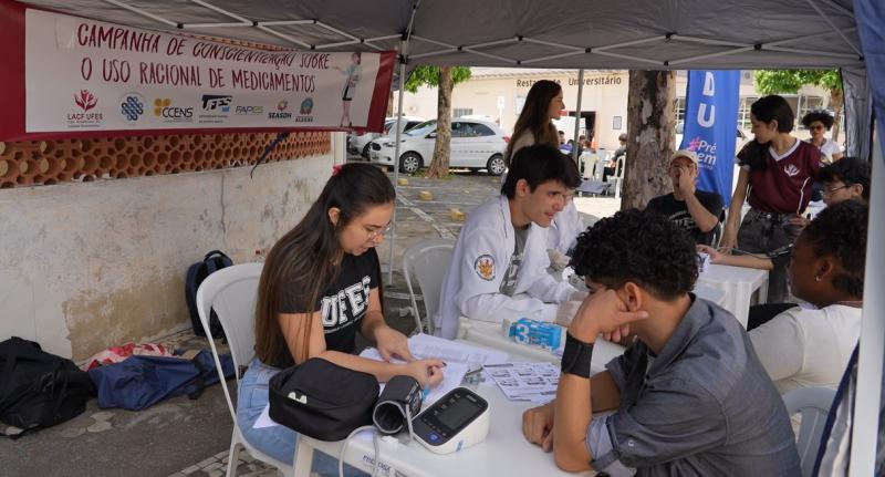 Foto do atendimento em um estande sobre uso racional de medicamentos