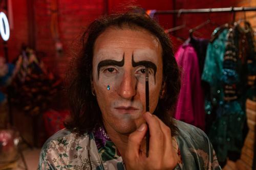 Foto do filme A Filha do Palhaço mostra o personagem principal fazendo sua maquiagem de palhaço