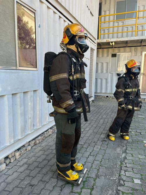 Bombeiro com uniforme de combate a incêndio sobre uma balança