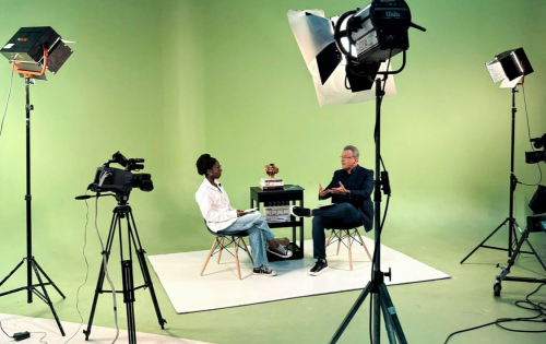 Foto de uma estudante entrevistando um homem no estúdio