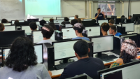 Foto de uma aula com os alunos no laboratório de informática