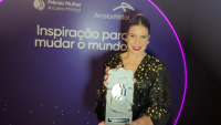 Foto da médica Júlia Polido com o prêmio recebido