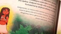 Foto da página de um livro infantil onde aparece um parágrafo escrito em língua indígena e, embaixo, em português