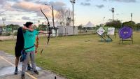 Foto de um jovem praticando no campo de tiro com arco da Ufes