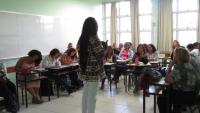 Foto de um professor negro diante de uma sala de aula