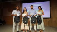 Foto dos estudantes premiados com o professor Gustavo Simão diante do painel de apresentação