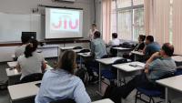 Grupo de pessoas assistindo a uma apresentação em uma sala