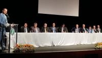 Foto da posse com o defensor público discursando e as autoridades sentadas à mesa