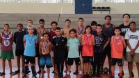 Grupo de crianças posando para foto em uma quadra de futsal 