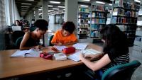 Foto de três alunas estudando em uma mesa da Biblioteca Central