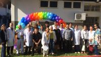Foto de toda a equipe em frente ao ambulatório, decorado com um arco de balões coloridos