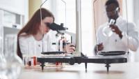 Imagem de uma pesquisadora branca e um pesquisador negro trabalhando em um laboratório