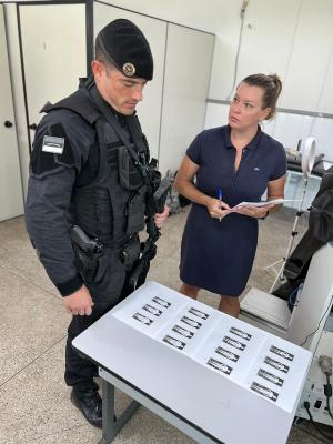 Policial fardado observa desenhos de tipos de um tórax, acompanhado por uma pesquisadora