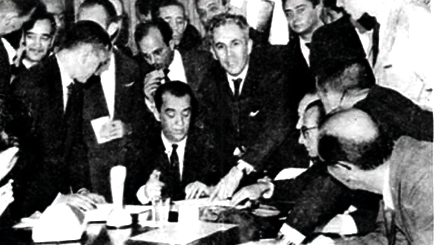 O presidente Juscelino Kubitscheck (sentado, ao centro) assina o decreto de federalização da Universidade; à sua esquerda, em pé, o deputado federal Dirceu Cardoso, protagonista naquele processo – janeiro de 1961