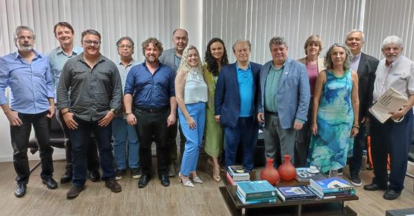 Foto dos participantes da reunião no gabinete do reitor. Descrição do nome das pessoas no texto