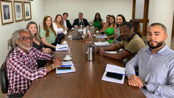 Foto de todos os participantes da reunião reunidos em torno da mesa