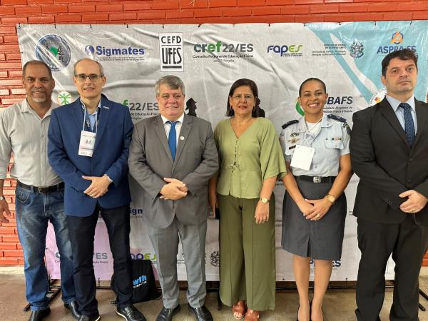 Foto das autoridades posando em frente ao banner do evento