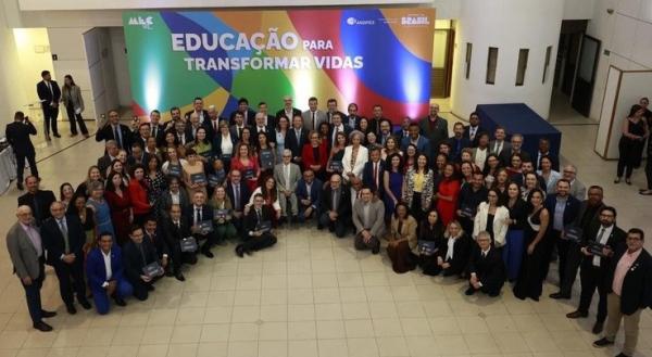 Foto de cima de todos as pessoas que receberam a carteira na solenidade
