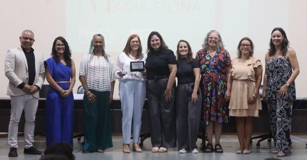 Foto da entrega da homenagem à professora Angélica