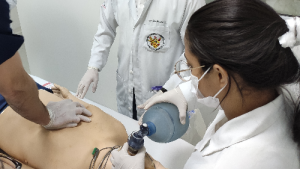Foto de profissionais de saúde treinando um procedimento em um boneco