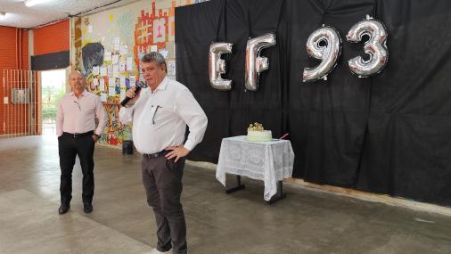 Foto do reitor e do diretor do Centro no hall. Ao fundo, um bolo e balões com as letras EF (de educação física) e o número  93