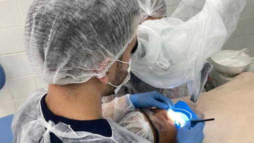 Foto de um dentista atendendo a uma pessoa no consultório