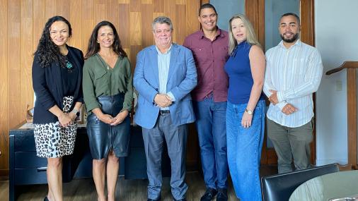 Foto dos participantes da reunião em pé, no gabinete do reitor