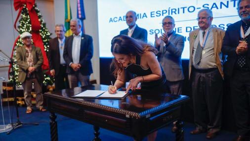 Foto da professora Adriana Campos assinando o livro de posse 