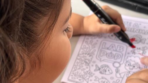Foto de uma criança pintando uma figura no papel