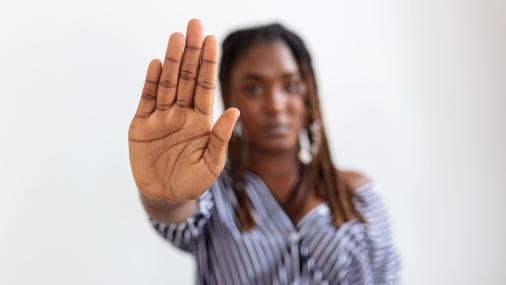 Imagem de uma mulher com a mão estendida em sinal de "pare"